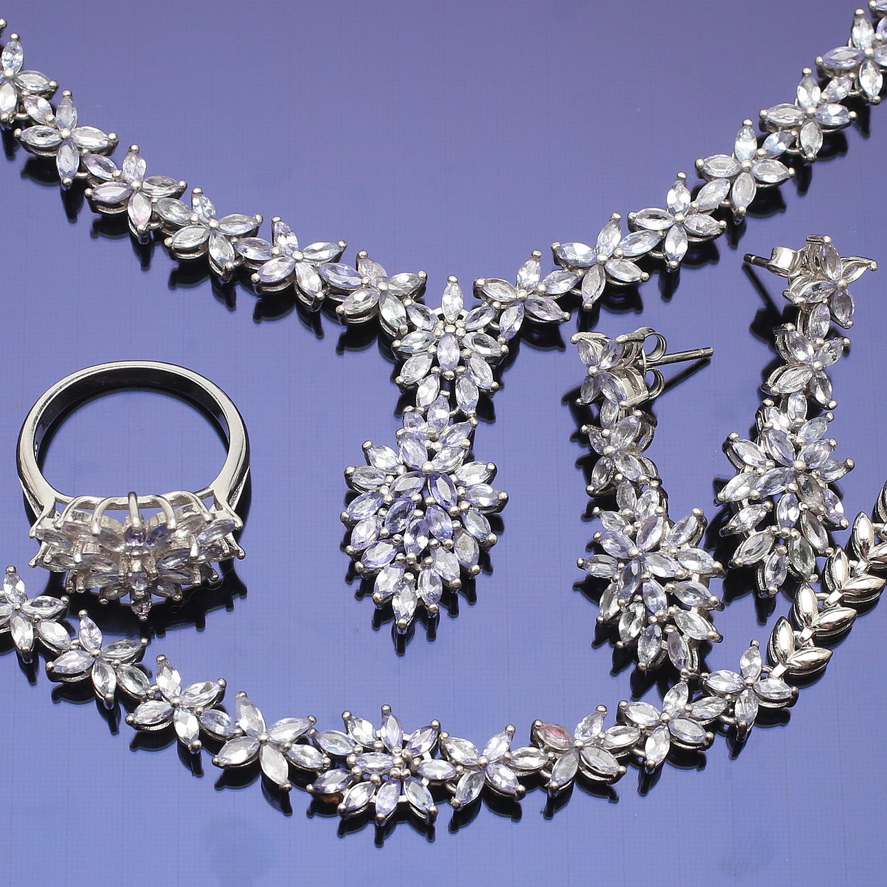 SMYCKESSET, vitguldspläterat sterlingsilver med tanzaniter, ca 12,15 ct, totalvikt 62,01 gram.