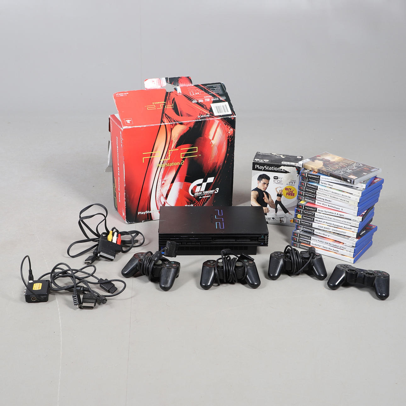 A PLAYSTATION TWO GAMES CONSOLE WITH TWO CONTROLLERS AND VARIOUS GAMES.