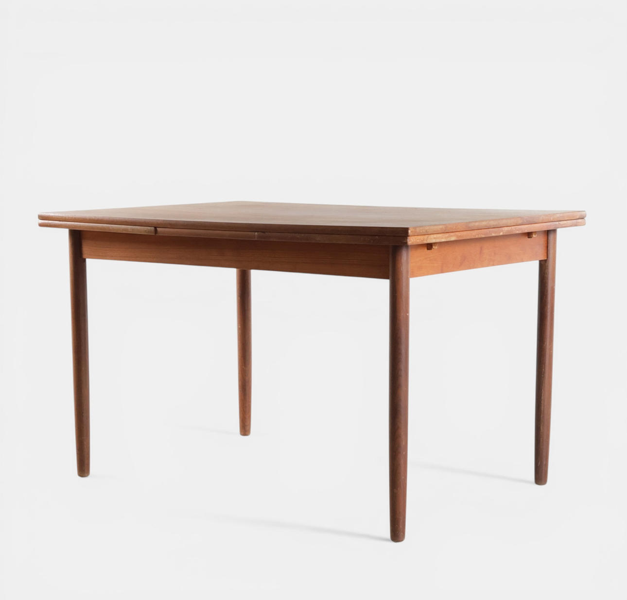 Rectangular dining table in teak, top with Dutch pull-out leaves, round tapered legs. Denmark, 1960s.