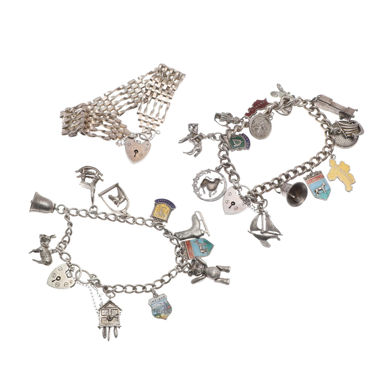 TWO SILVER BRACELETS WITH ATTACHED CHARMS AND A GATE BRACELET.