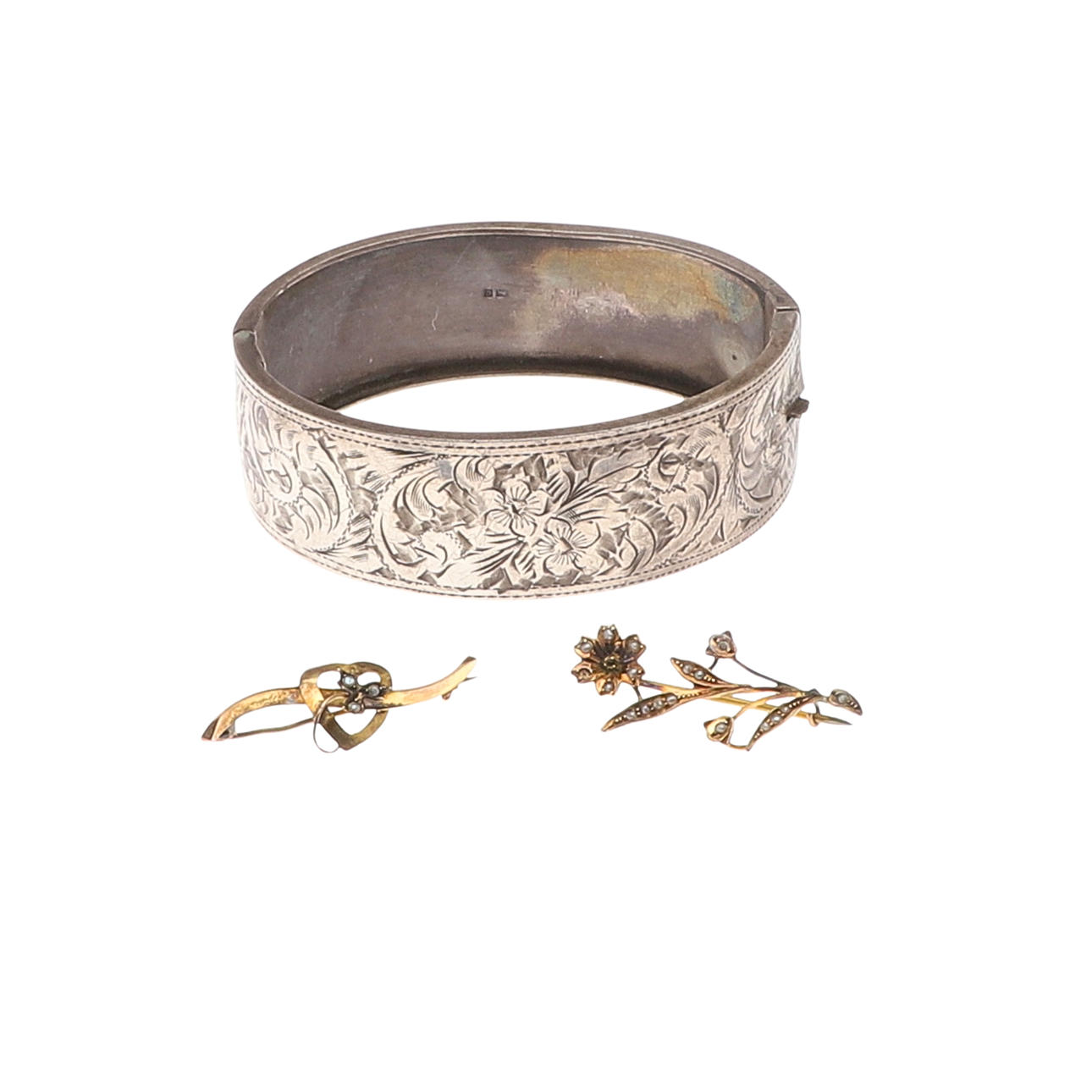 A 1950S SILVER CUFF BANGLE AND TWO 9CT GOLD BROOCHES.