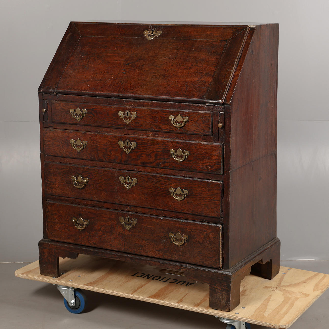 AN EARLY GEORGE III OAK BUREAU.