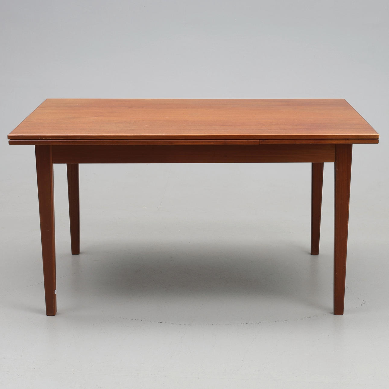 DINING TABLE. Teak, 1960s, with pull-out extension leaves.