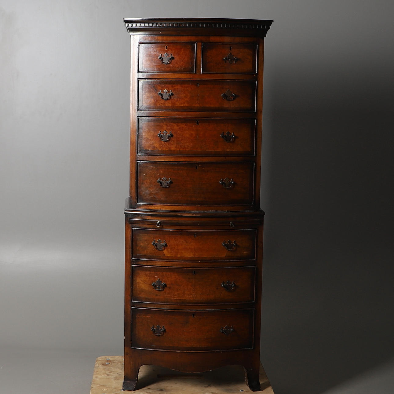 A 20TH CENTURY WALNUT BOW FRONTED TALLBOY CHEST.