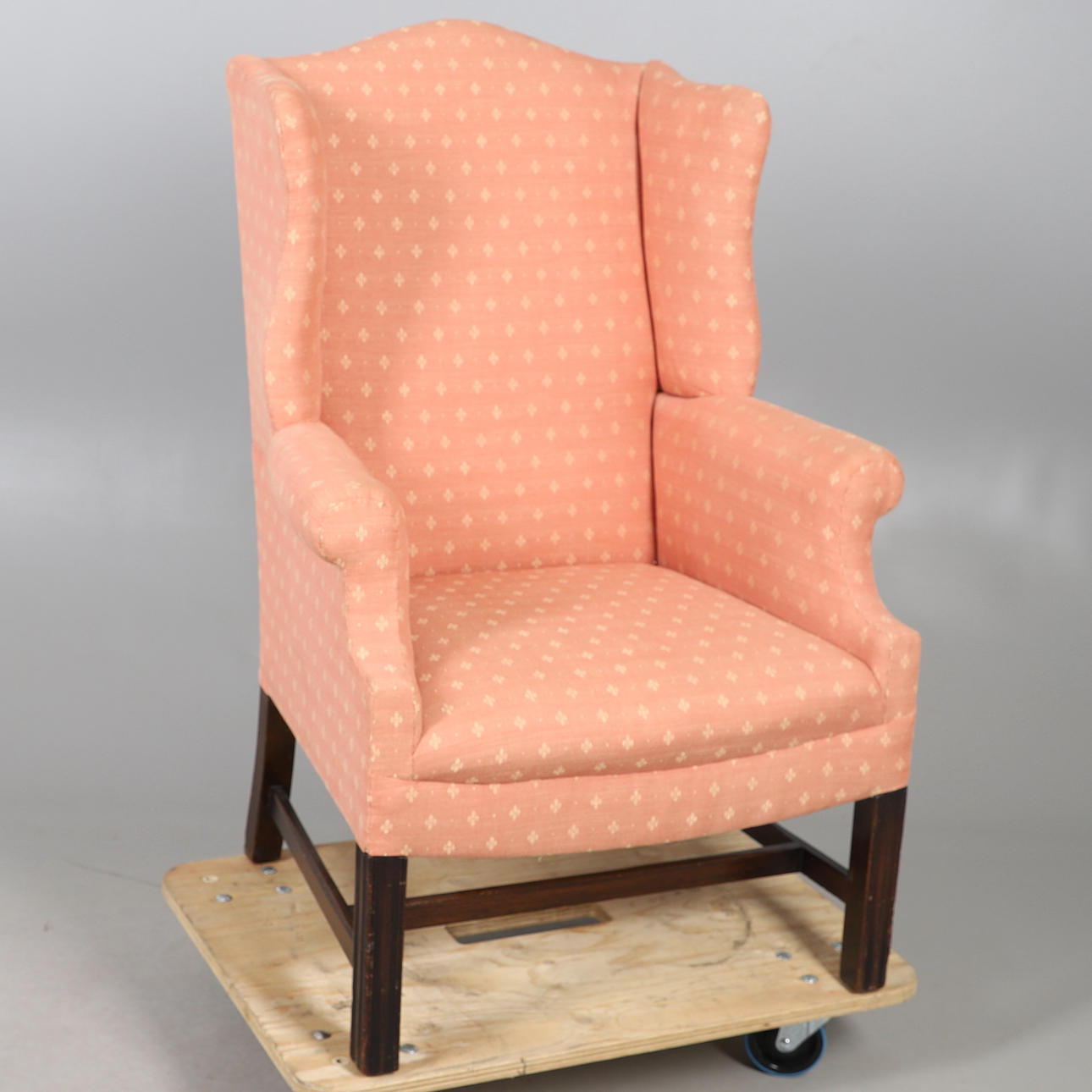 AN UPHOLSTERED WINGBACK ARMCHAIR.