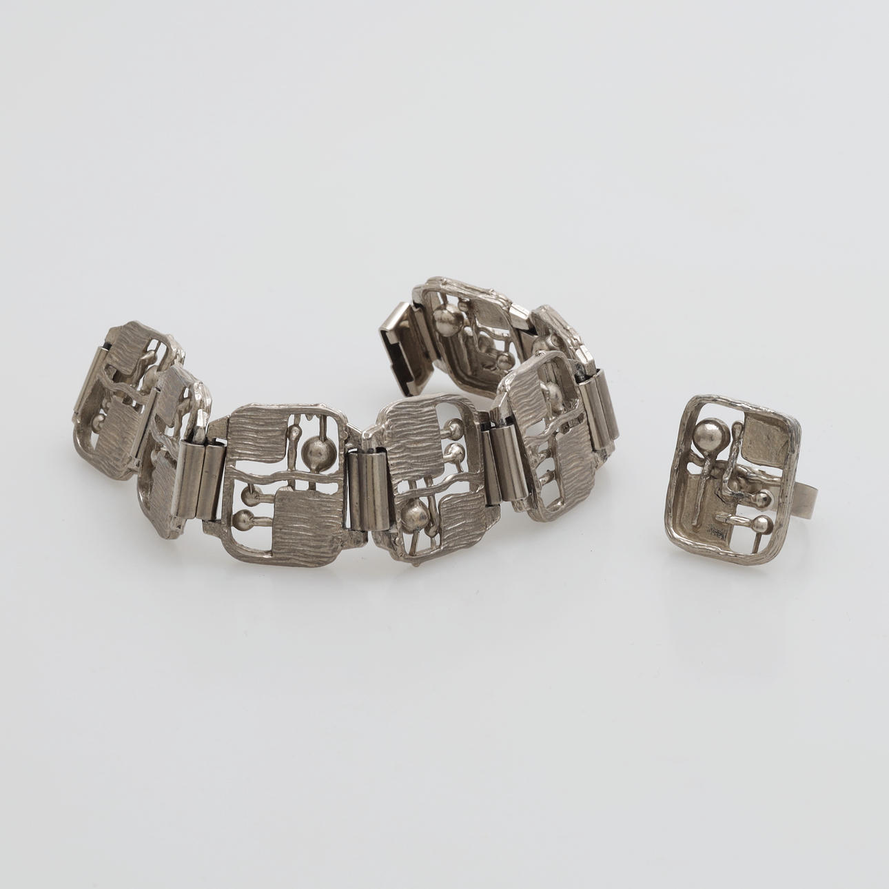 ARMBAND OCH RING, tenn, 1900-talets andra hälft.