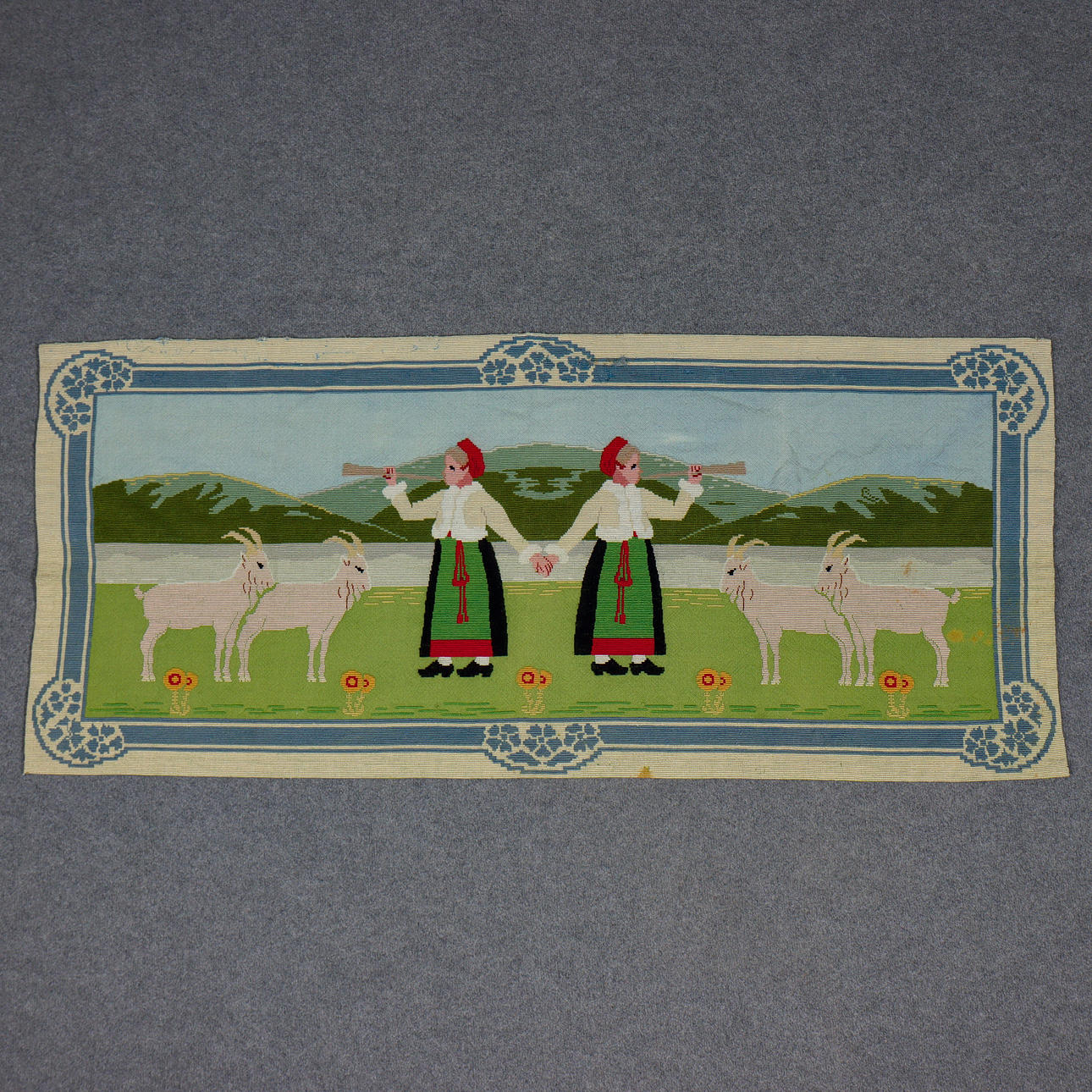 VÄGGBONAD, VÄVD I YLLE OCH SEDAN BRODERAD ca 1900. MOTIV AV DALKULLOR MED NÄVERLURAR. PROVENIENS, SATT I GAMLA KÖKET PÅ HERRGÅRDEN I FÅGELFORS.