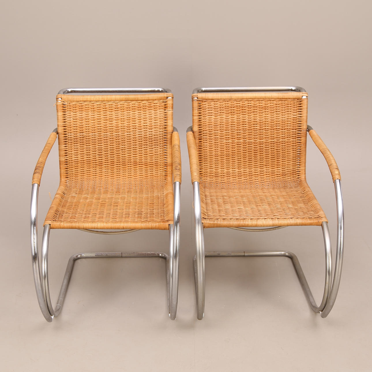 LUDWIG MIES VAN DER ROHE. TILLSKRIVEN. KARMSTOLAR, ett par, kromad stålrörsram, beige rotting, stil enligt - Barcelona chair modell MR20, Bauhaus - Tyskland, 1900-tal.