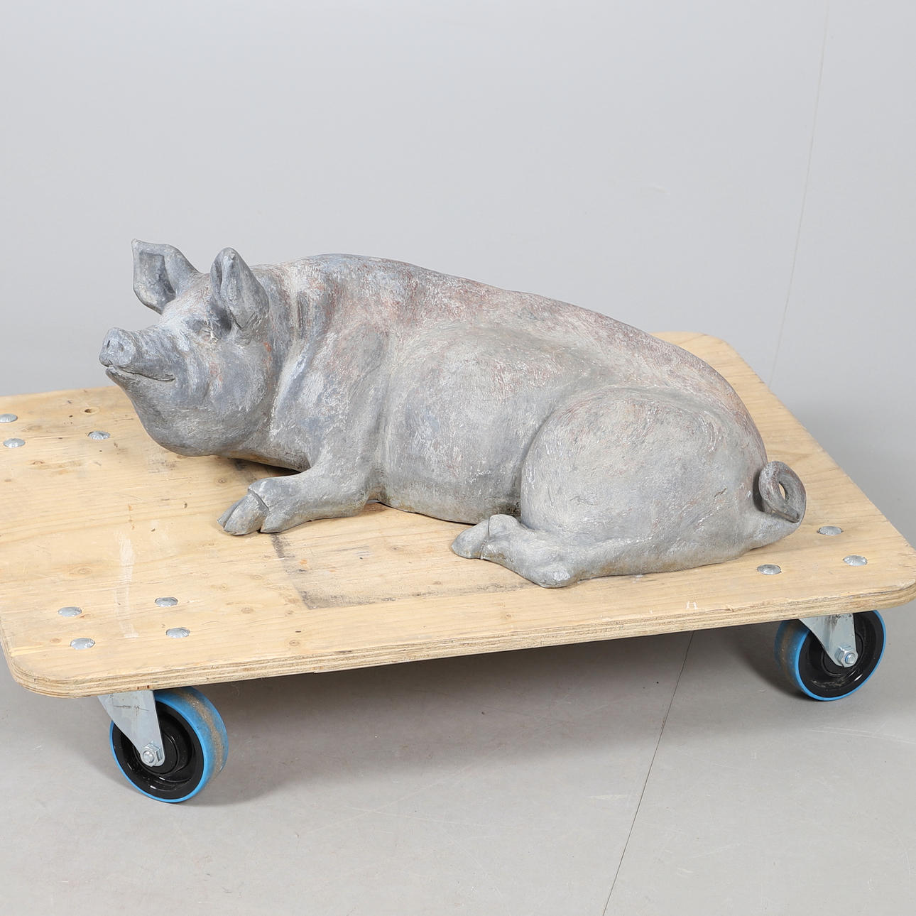 A LEAD RECUMBENT PIG.