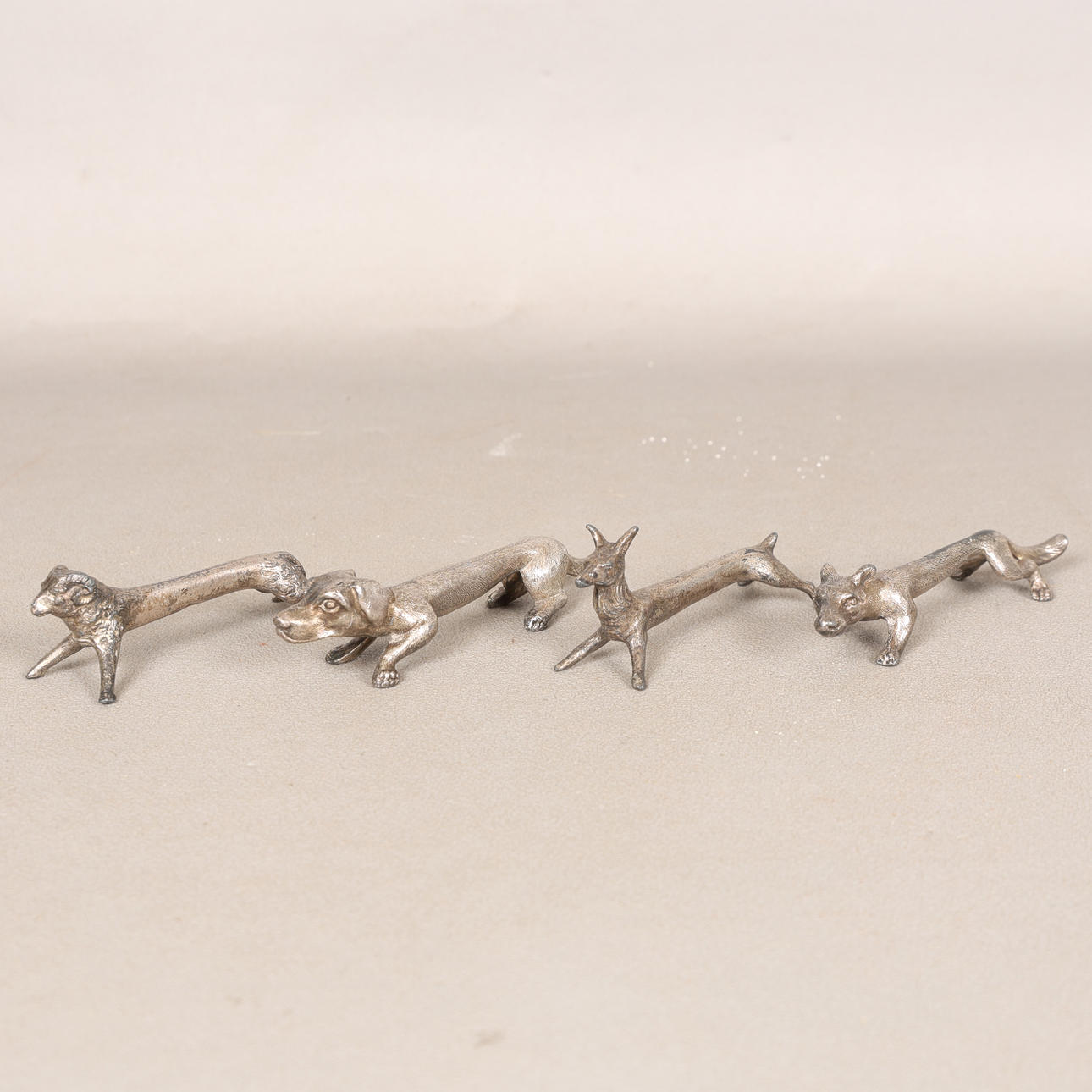 FOUR SILVER PLATED KNIFE RESTS (4).