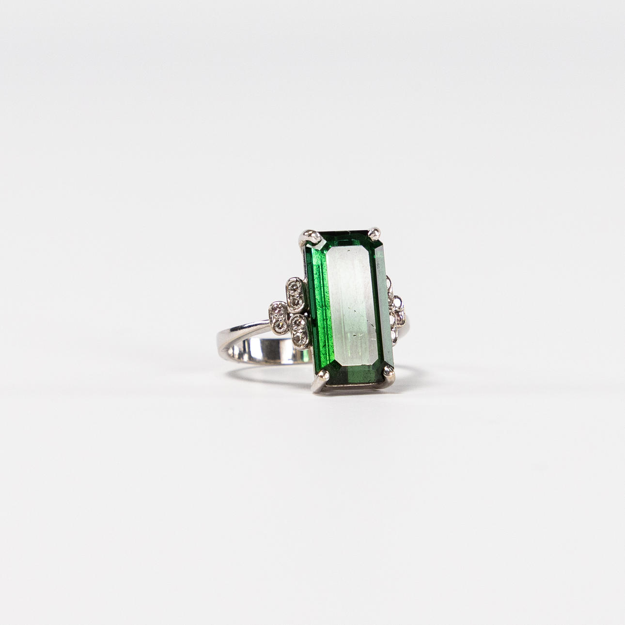 RING. 18k guld, små vita stenar, stor grön sten.
