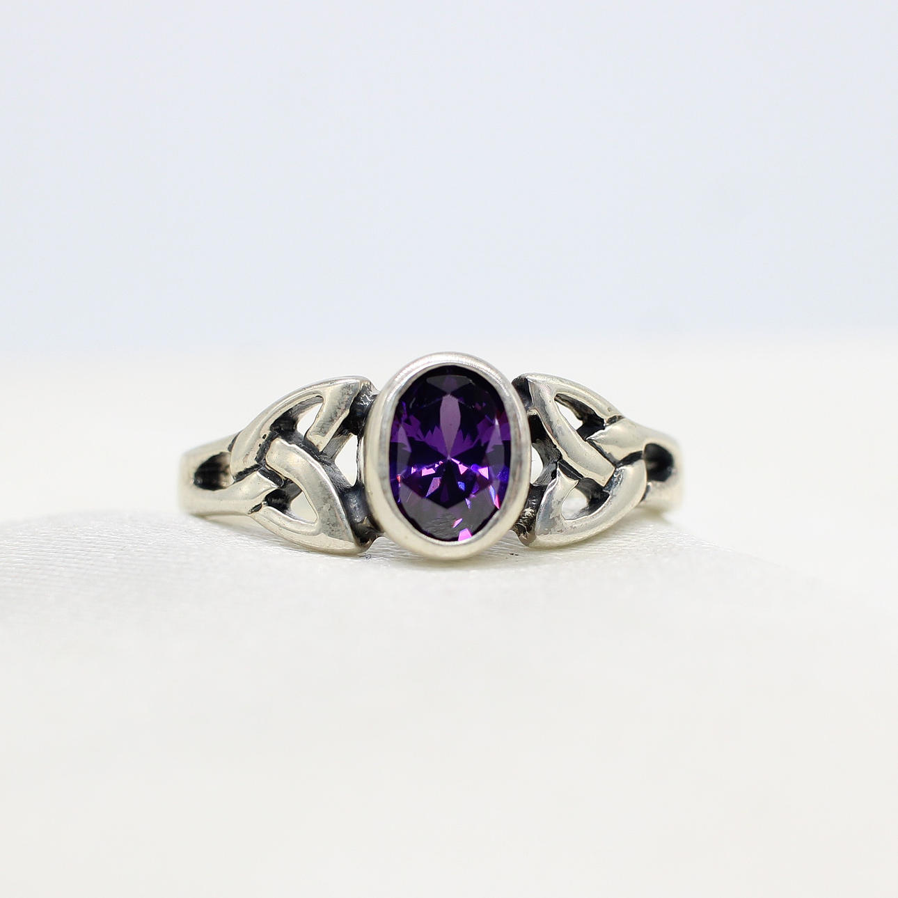 SILVER CELTIC RING WITH PURPLE CUBIC ZIRCONIA.
