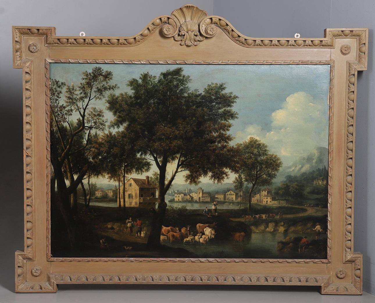 FOLLOWER OF FRANCESCO ZUCCARELLI (1702-1788). FIGURES AND CATTLE BESIDE A LAKE WITH A VILLAGE BEYOND.