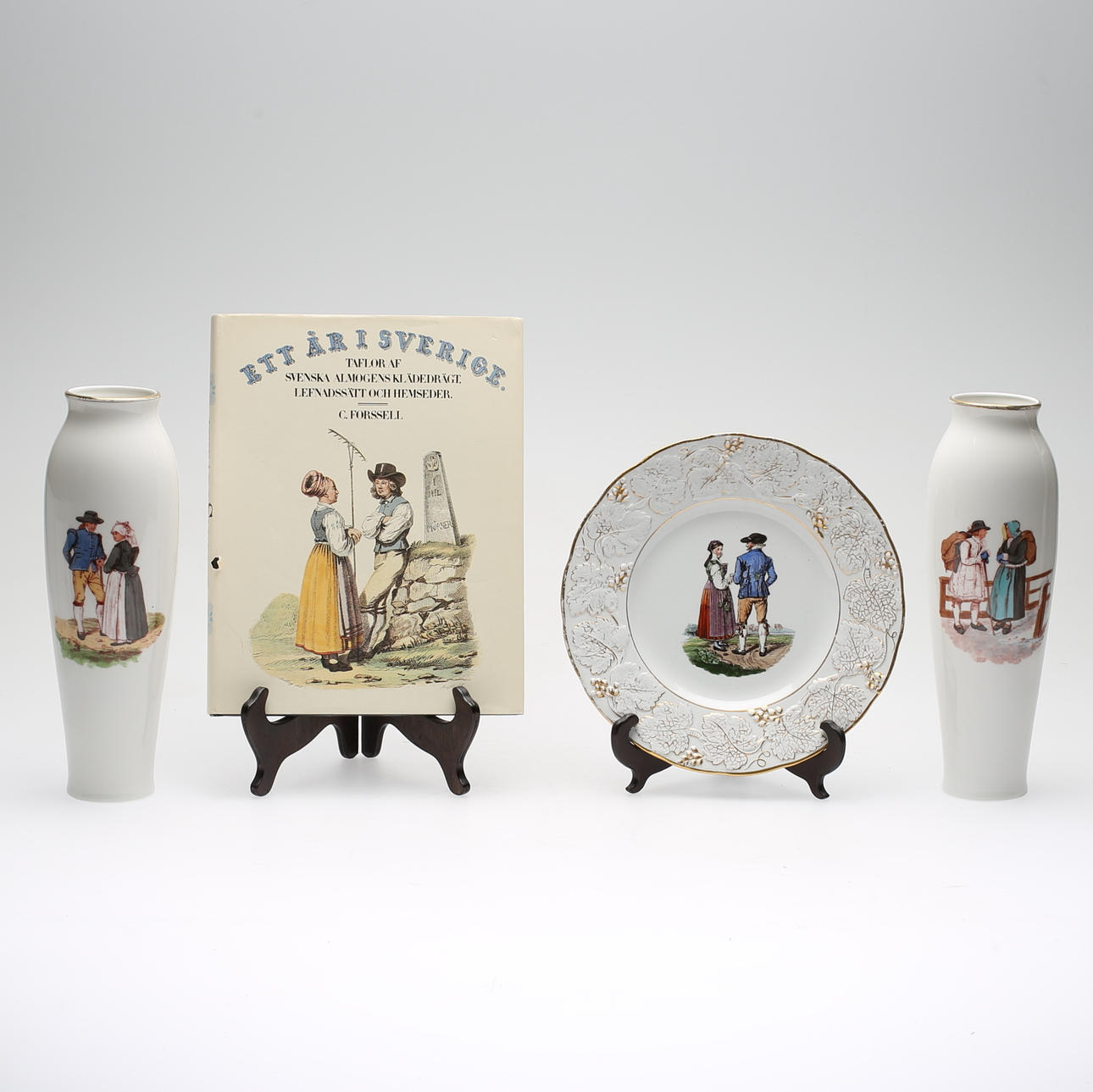 'ETT ÅR I SVERIGE', parti med bl.a ett par vaser, fat samt bok, Rörstrand, 1900-talets första del.