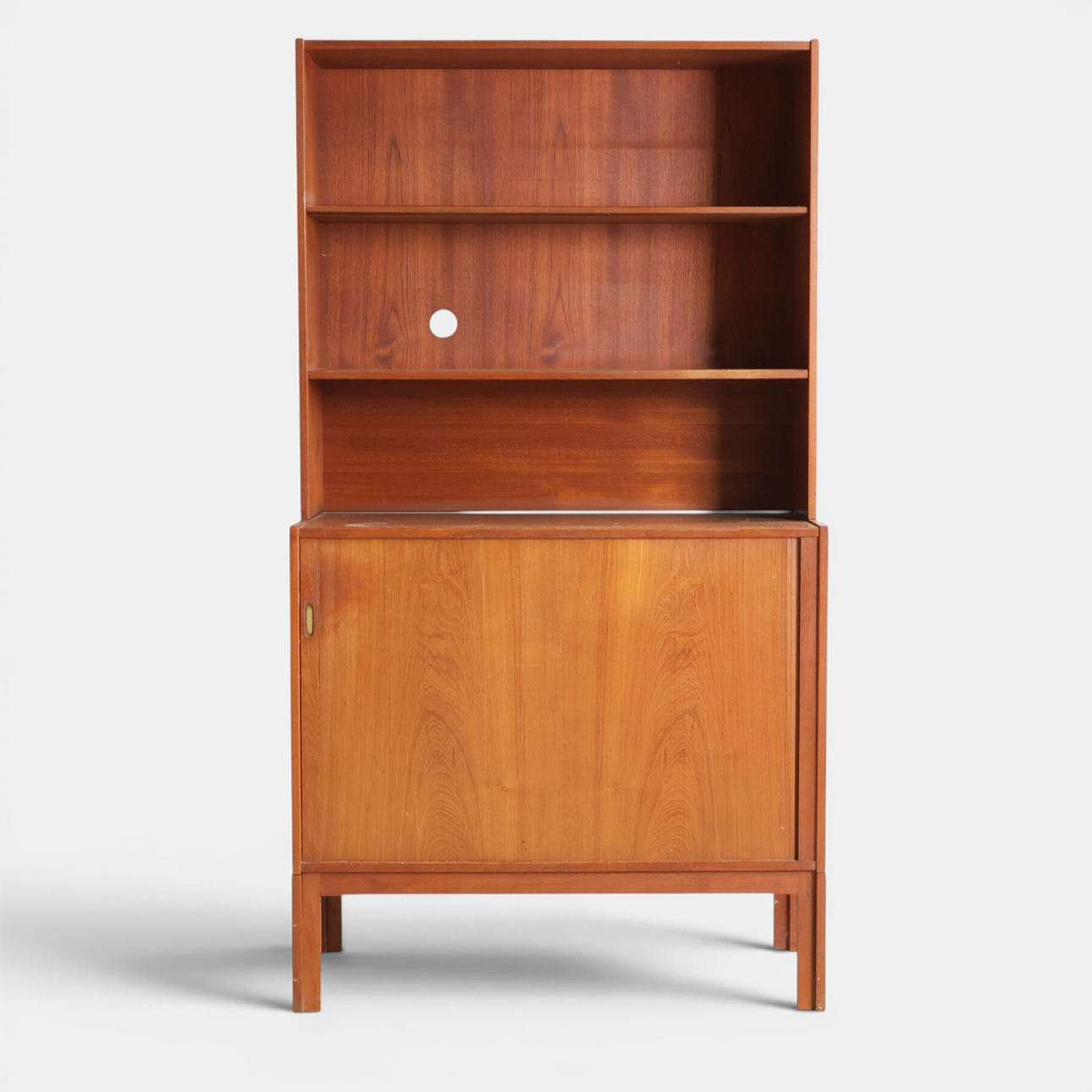 Low sideboard with top section, front with tambour door behind which are pull-out trays, above this a top section with shelves, profiled frame. Denmark, 1960s (2).