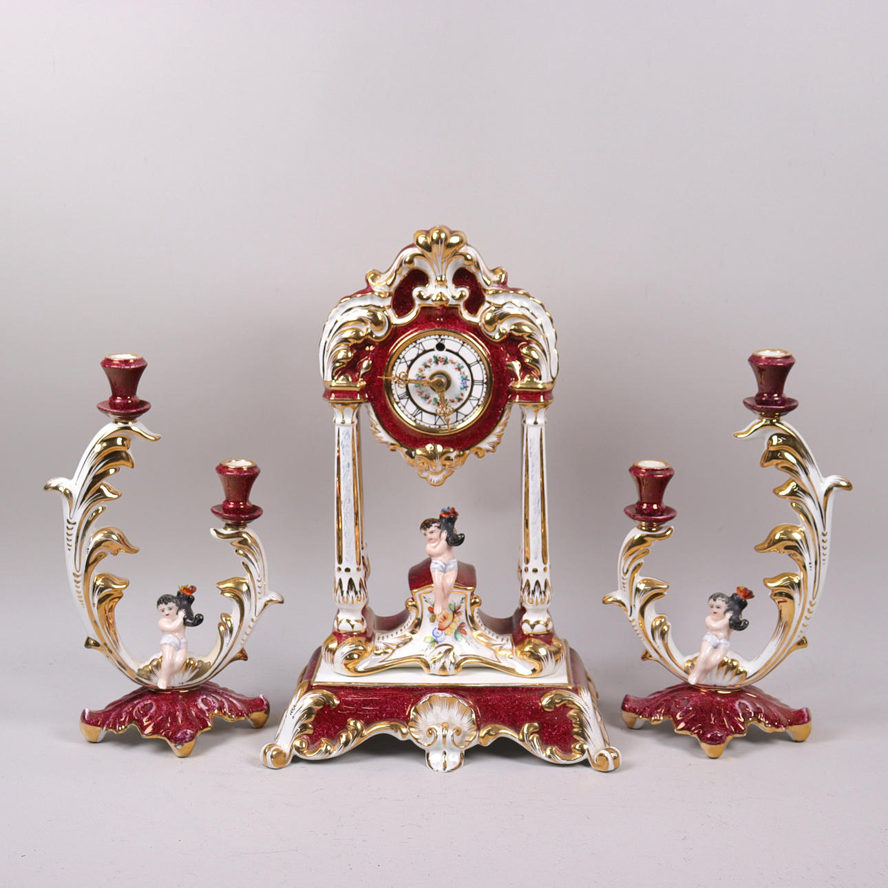 TABLE CLOCK with candlesticks, porcelain with figural decoration.