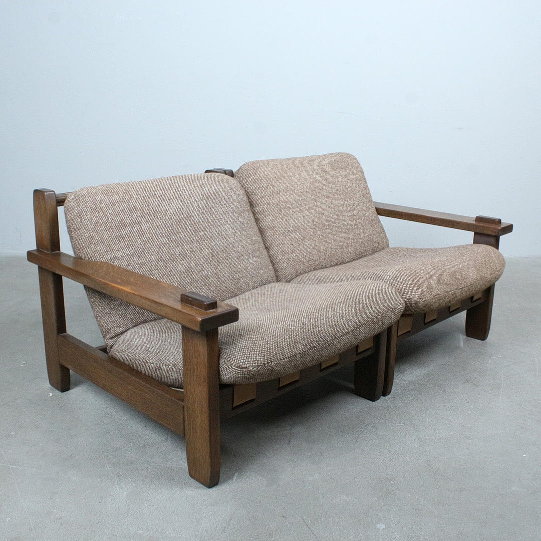 ATTRIBUTED TO CARL STRAUB. Two Brutalist two-seater sofas/armchairs in oak, Denmark, 1970s.