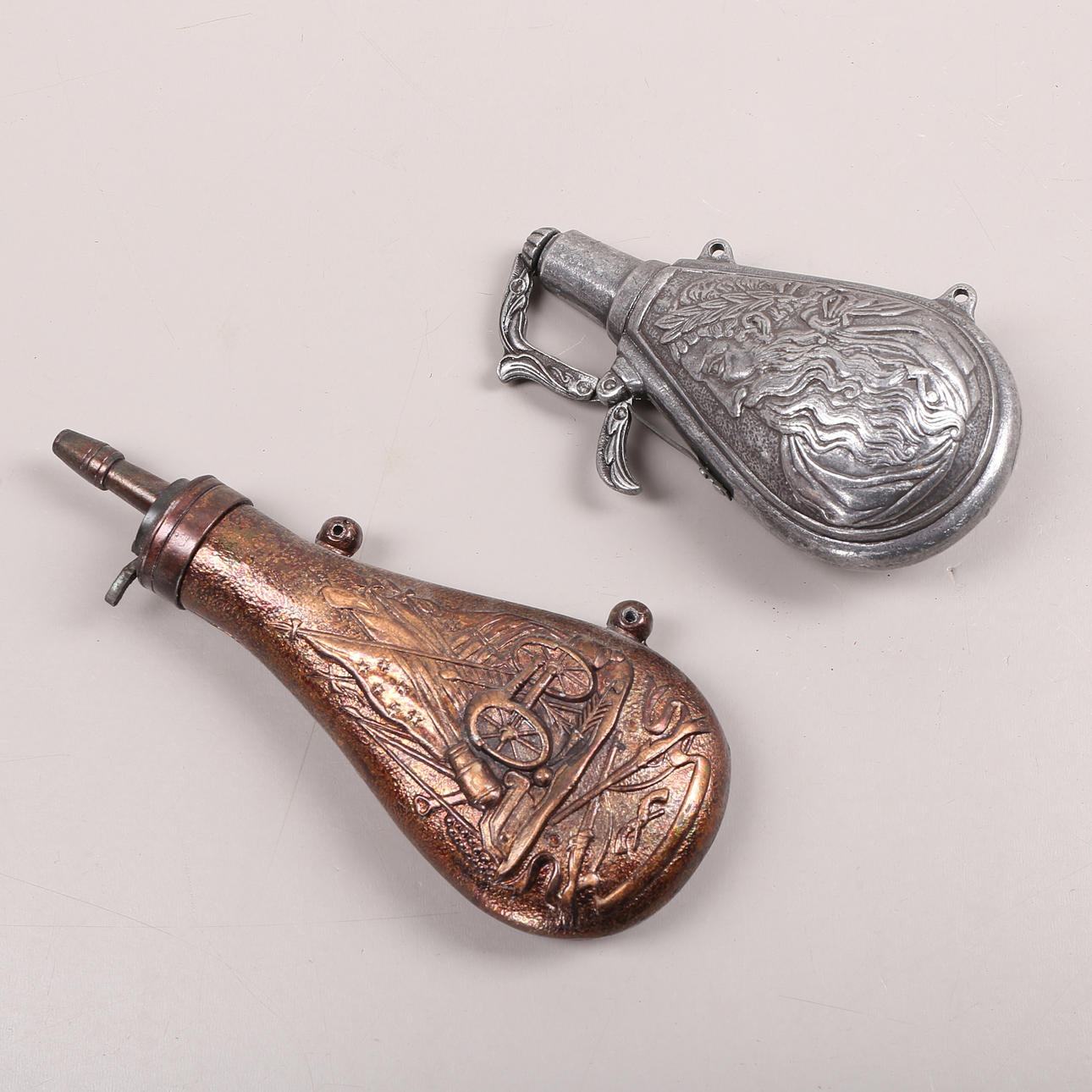 POWDER FLASKS, 2 pcs, metal, 20th century.