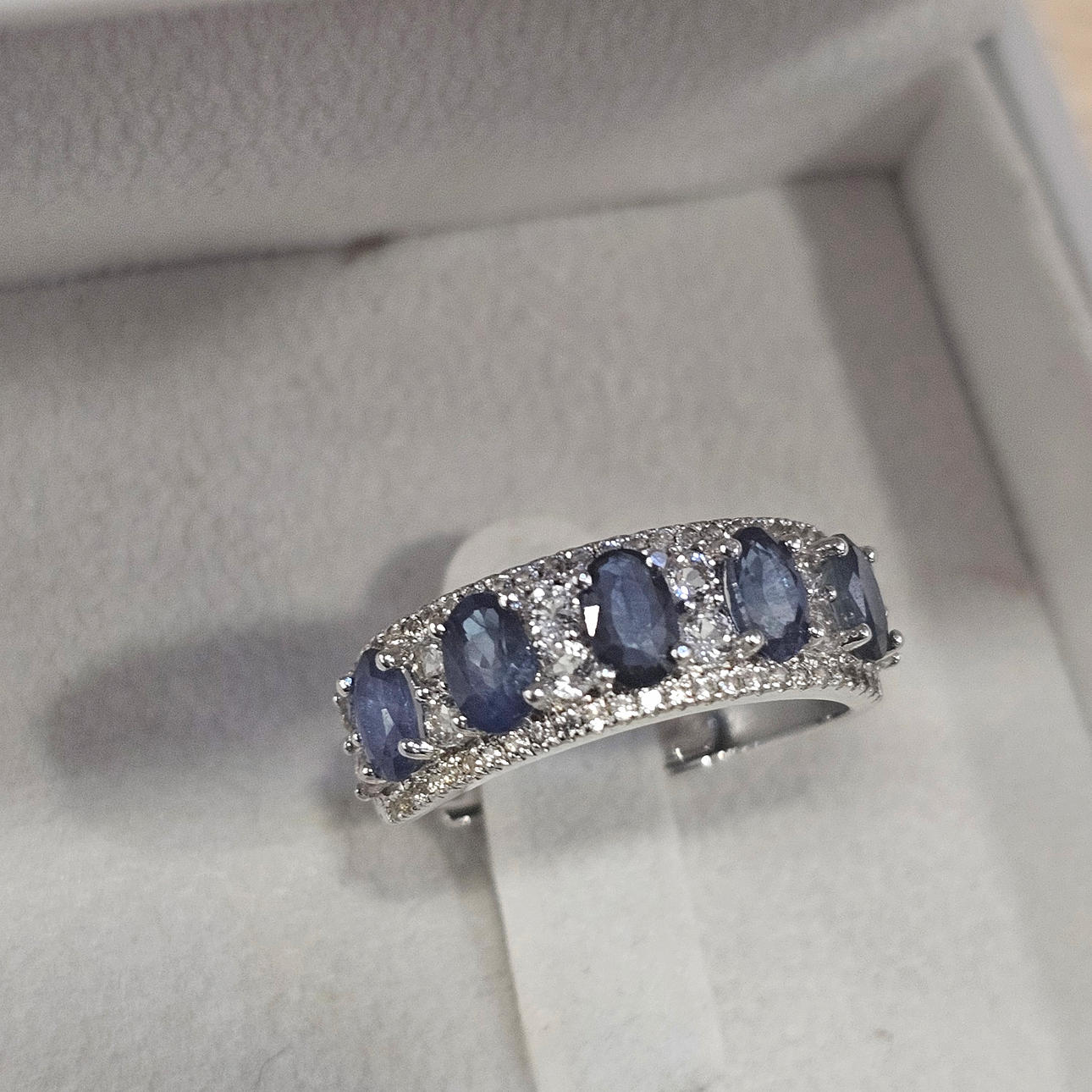 Half eternity ring in silver with blue and white sapphires.