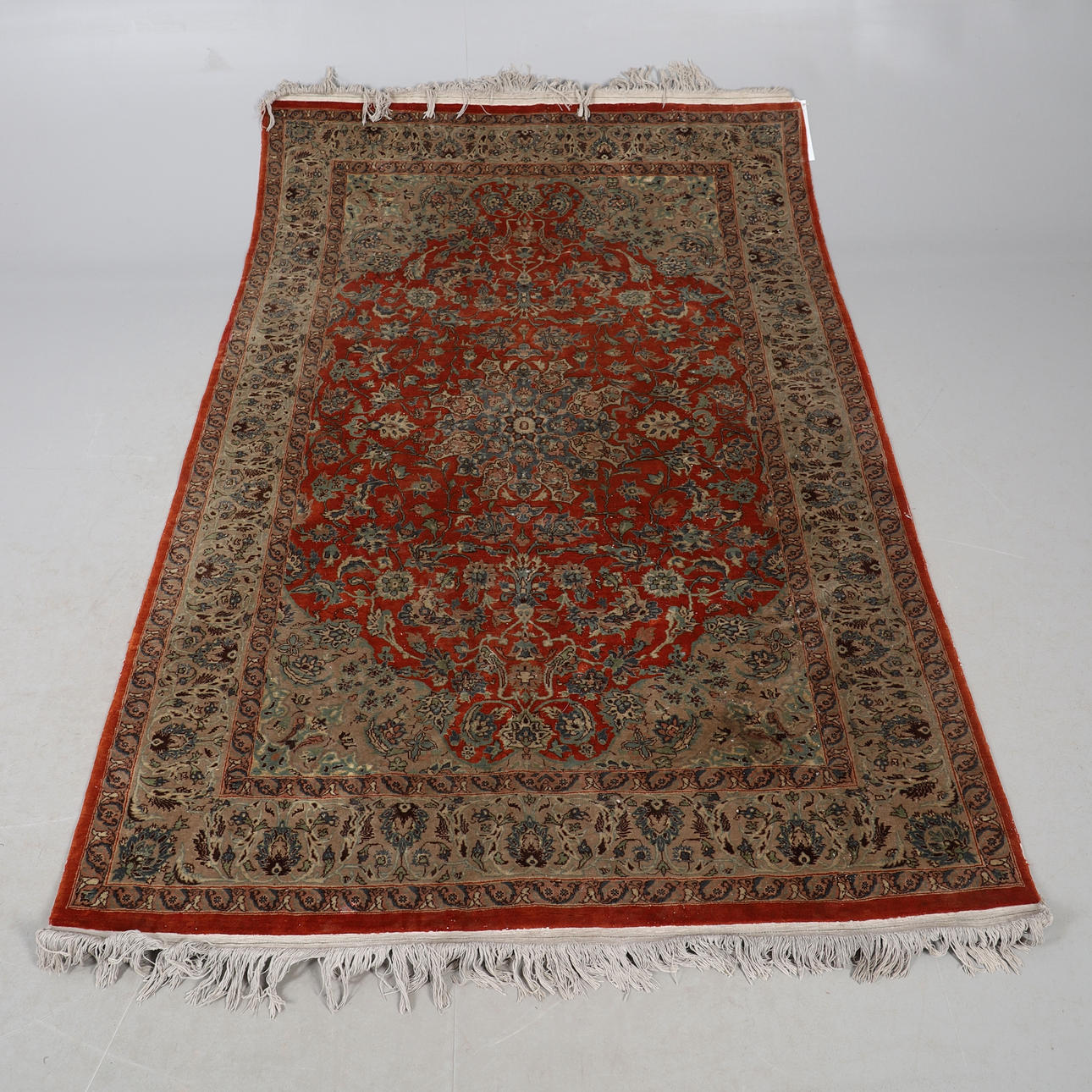 AN ORIENTAL RUG.