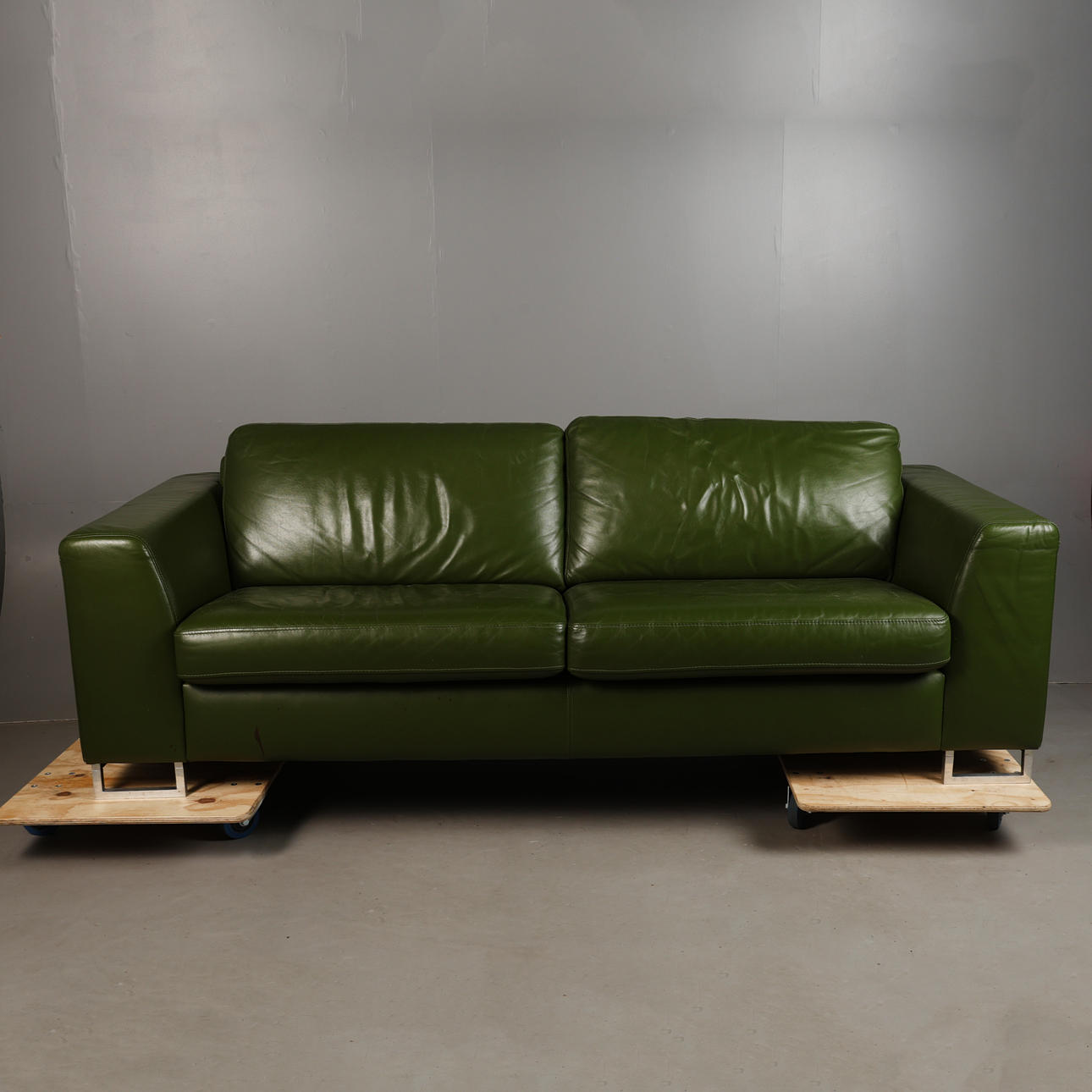 GREEN UPHOLSTERED SETTEE.