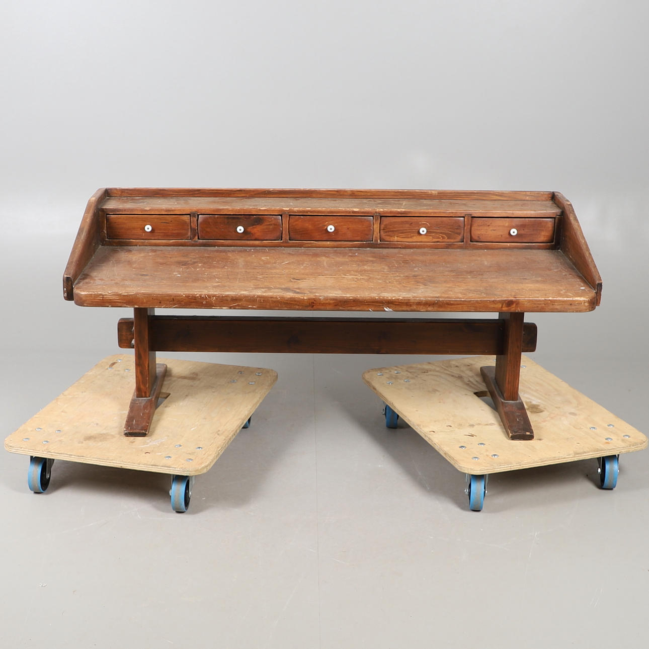 A STAINED PINE WORK BENCH.