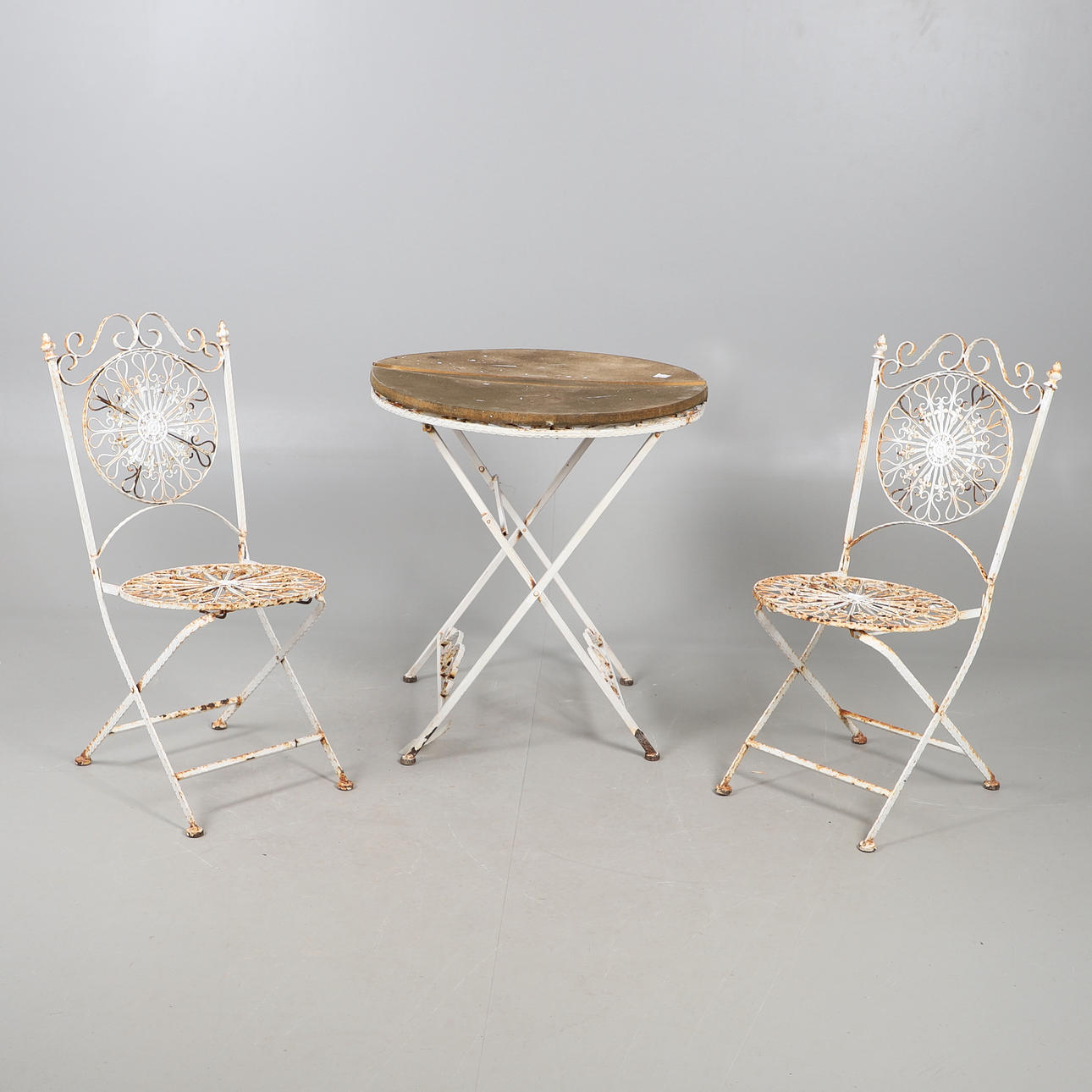 A WROUGHT GARDEN TABLE AND TWO CHAIRS.