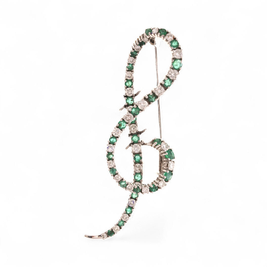 Treble clef-shaped diamonds and emeralsd brooch.