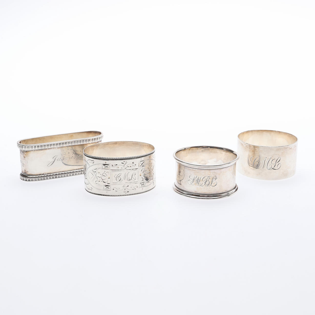 4 SILVER NAPKIN RINGS.