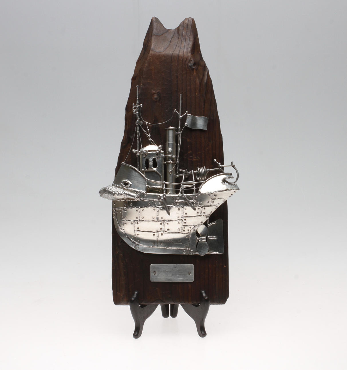 URBAN STRÖM. "Bogserbåt".Väggskulptur, tenn monterad på drivved, signerad och daterad -86.