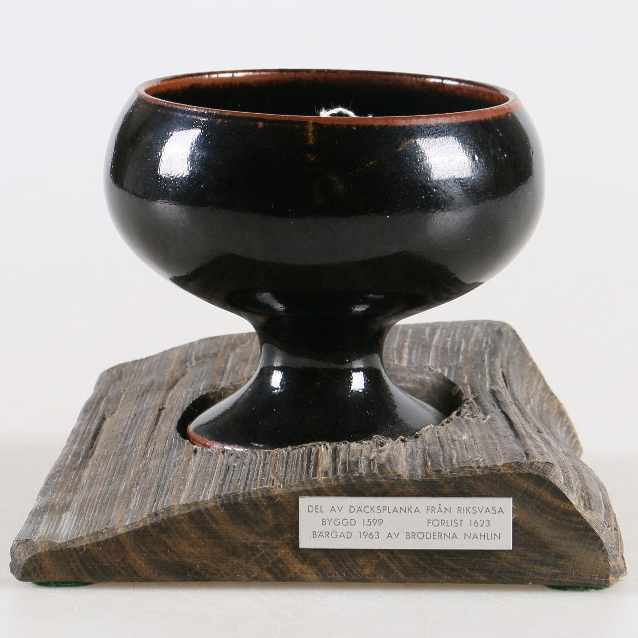 LJUSSTAKE PÅ FOT, stengods, monterad på del av däcksplanka från Riksvasa, förlist 1623.