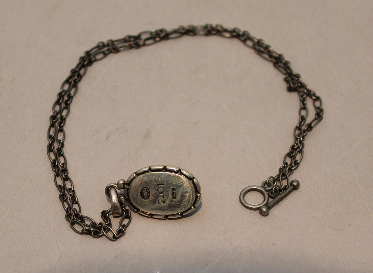 GEORG JENSEN. ÅRSSMYCKE 2001. Sterling silver med bärnsten.