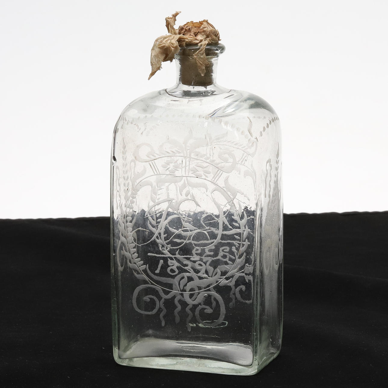 BRÄNNVINSFLASKA. Handblåst glas med etsad dekor och original kork, märkt 1832.