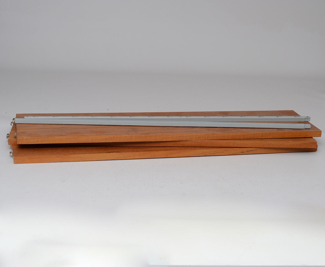 "Stringhylla", grå konsoler, hyllplan i teak.