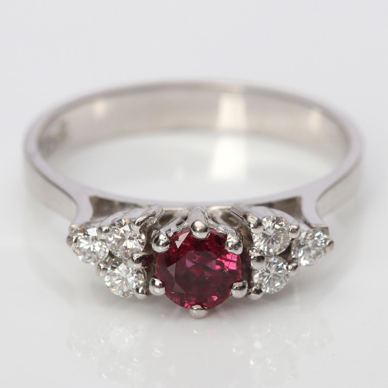 RING. 18k vitguld med en rund fasetterad rubin och briljantslipade diamanter, totalvikt ca 3,7 gram.