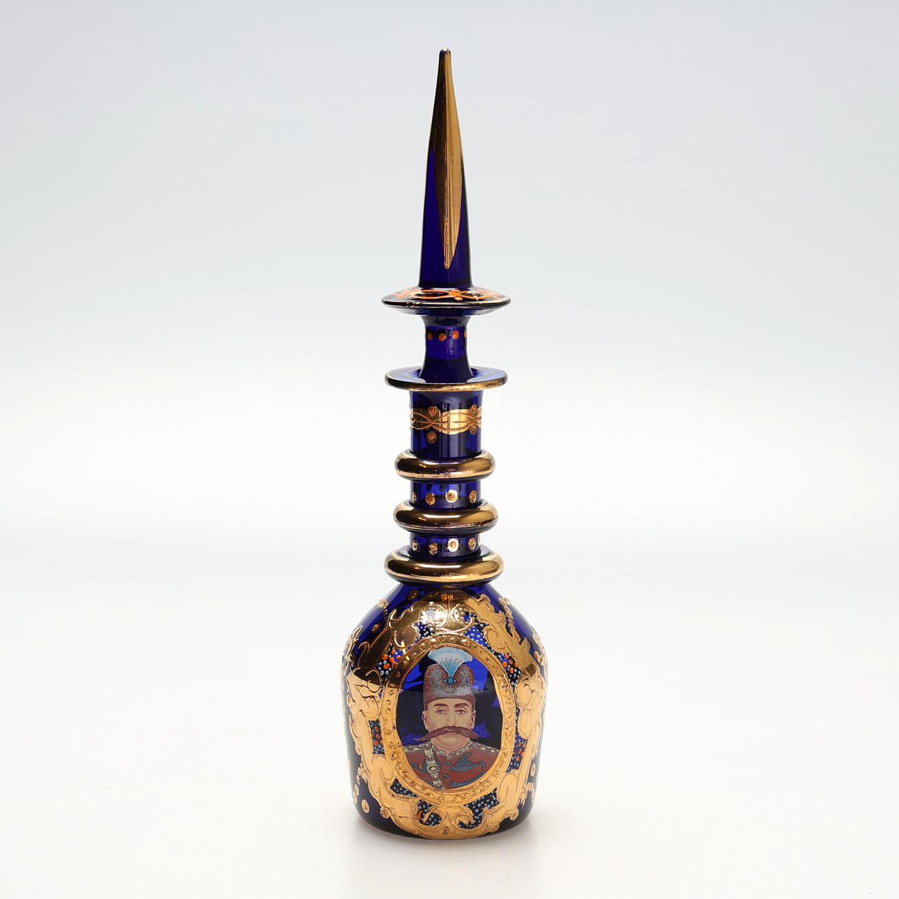 BOHEMISK KARAFF, förgyld i koboltblått glas, porträtt av Sultan Naser Al-Din Shah Qajar, 1900-talets första hälft.