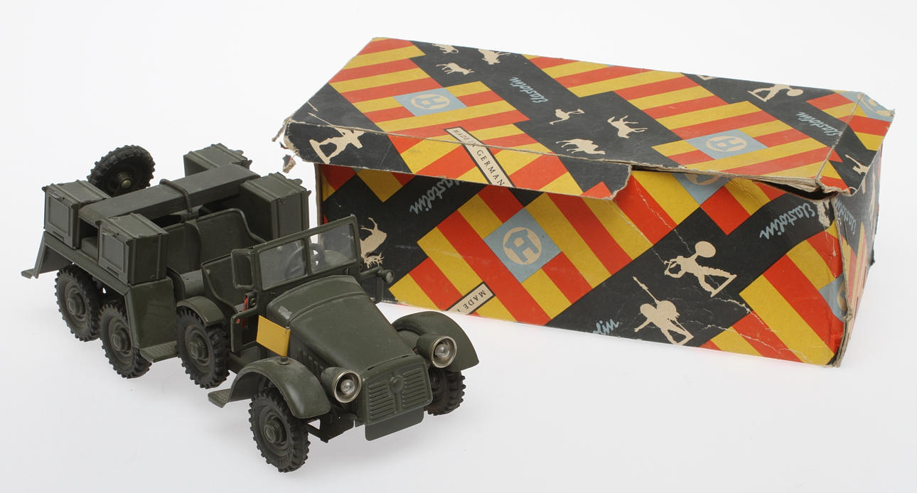 HAUSSER KRUPP Militärbil, elektriska strålkastare, gummihjul, urverk. Originalkartong.