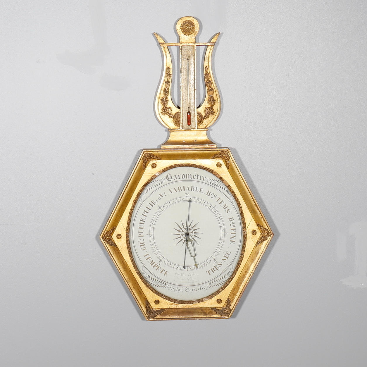 UN BARÓMETRO Y TERMÓMETRO FRANCÉS DE MADERA DORADA.