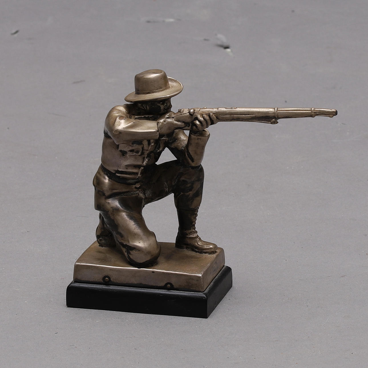 STATYETT, metall, man med gevär.