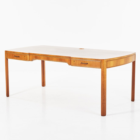 A 1960s-era Swedish desk, mahogany, indented sargen and with two ...