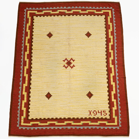 A RUG RUG, dated 1945, geometric decor in yellow field with maroon ...