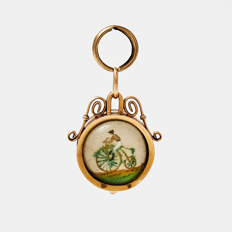 HÄNGE, doublé, sekelskiftet 18/1900, framsida med kompass, baksida med essex crystal med motiv av man på cykel.