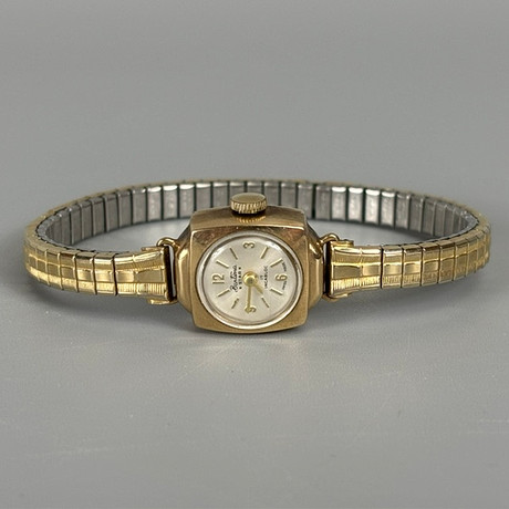 TISSOT STYLIST. A LADY'S VINTAGE GOLD CASED WRIST WATCH. Clocks