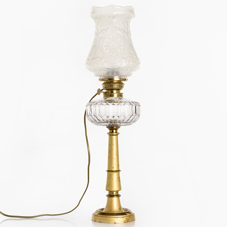 BORDSFOTOGENLAMPA, omkring år 1900, elektrifierad, fot i förgylld mässing, kupa gjutet glas med jugenddekor. P på auktion hos Crafoord Auktioner Stockholm