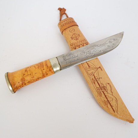 KNIV MED SLIDA, J Marttiini Finland, handtag av björk, slida av läder med dekor. på auktion hos Falun Auktionsbyrå