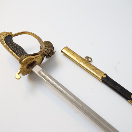 SJÖOFFICERSSABEL, Kungliga Flottan Model 1878/1915, Klinga med etsad dekor, parerskydd av mässing med dekor av på auktion hos Falun Auktionsbyrå
