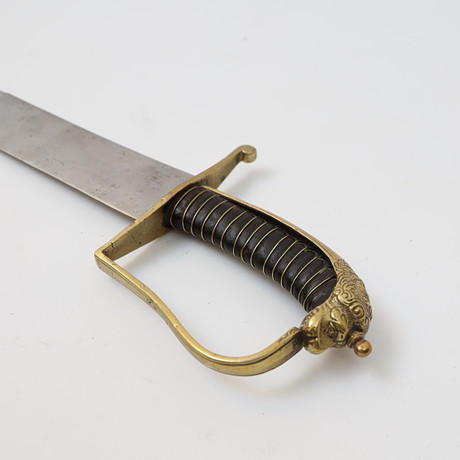 SABEL, Sverige 1800-tal, lindad handtag, med detaljer i mässing med dekor av lejon. Klinga av stål. på auktion hos Falun Auktionsbyrå