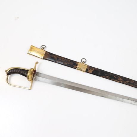 HUGGARE, 1800-tal, lindat handtag med detaljer i mässing, klinga av stål, balja av läder och mässing. på auktion hos Falun Auktionsbyrå