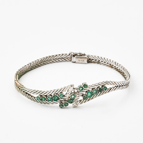 ARMBAND, 18 k rodierat och blankslipat vitguld, mittparti med dekor av 16 fasettslipade smaragder, Vicenz/Ital på auktion hos Stockholms Auktionsverk Magasin 5