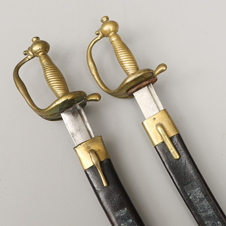 HUGGARE, 2 st., svenska, m/1748-1856, svarta läderbaljor med mässingsbeslag. på auktion hos Crafoord Auktioner Malmö